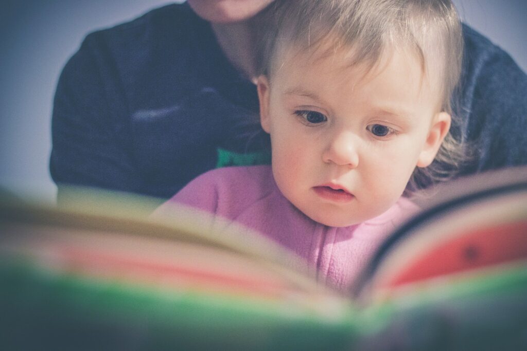 Menina lendo no colo. Imagem ilustrativa texto clube de leitura.